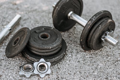 Free Metal dumbbell with additional details on ground Stock Photo