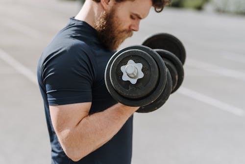 Concentrated man with dumbbells in hands