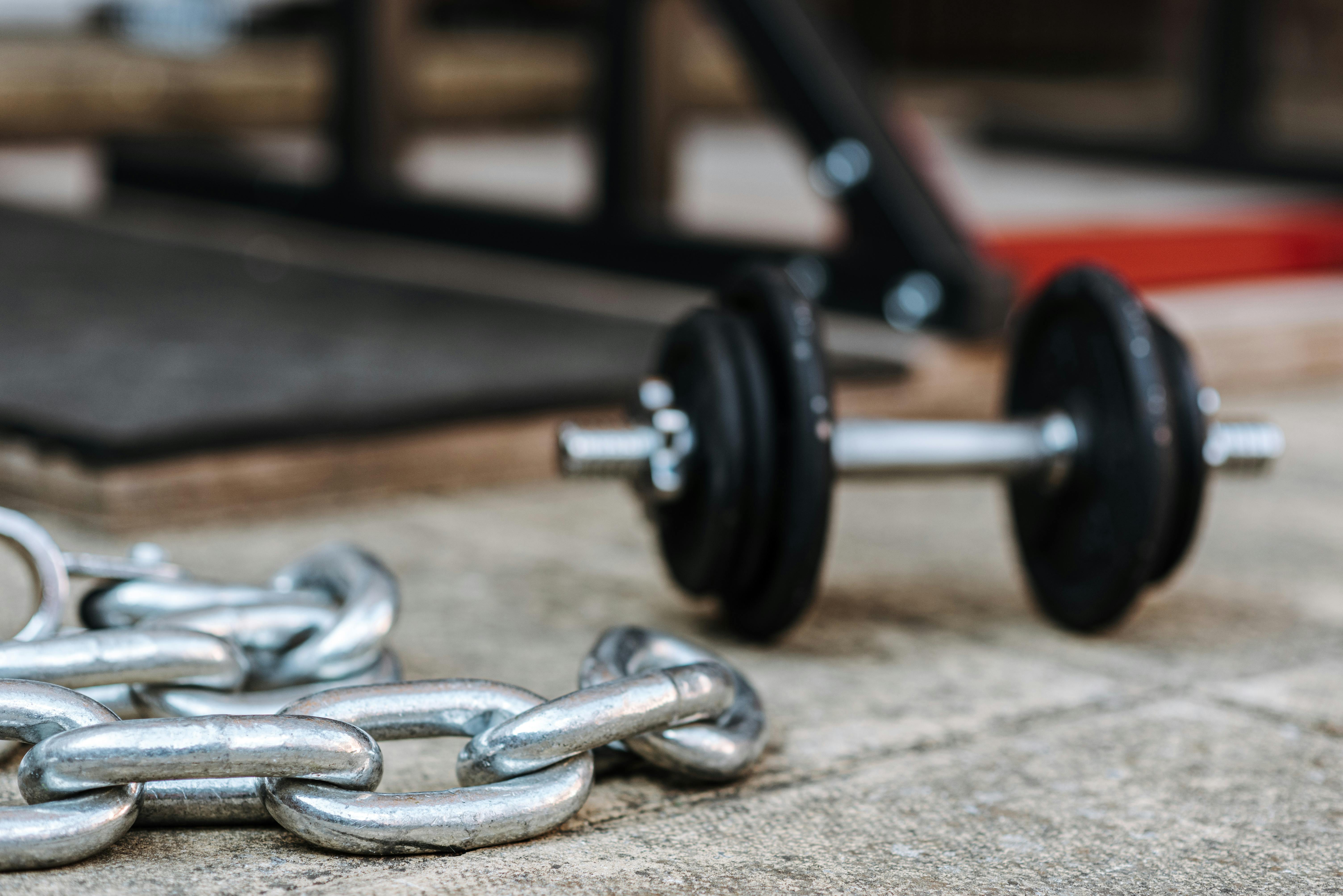 metal chain and dumbbell on tiled pavement