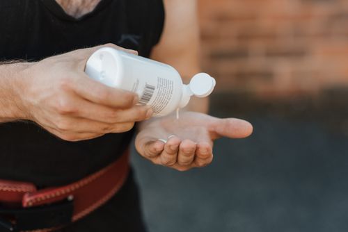 Free Close-up of a weightlifter applying liquid chalk to hands for grip. Stock Photo