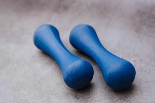 Free Modern similar blue dumbbells on gray background Stock Photo