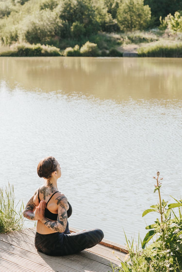 Anonymous Tattooed Woman Showing Reverse Prayer Pose Near River