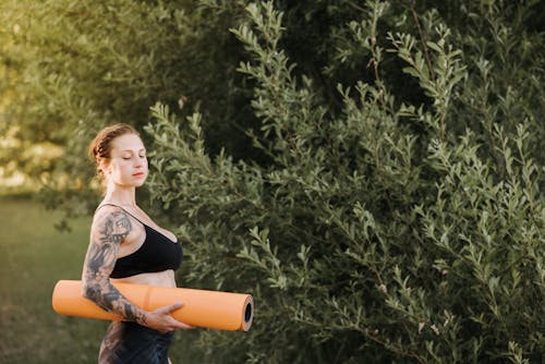 梦幻纹身的女人与树附近的瑜伽垫