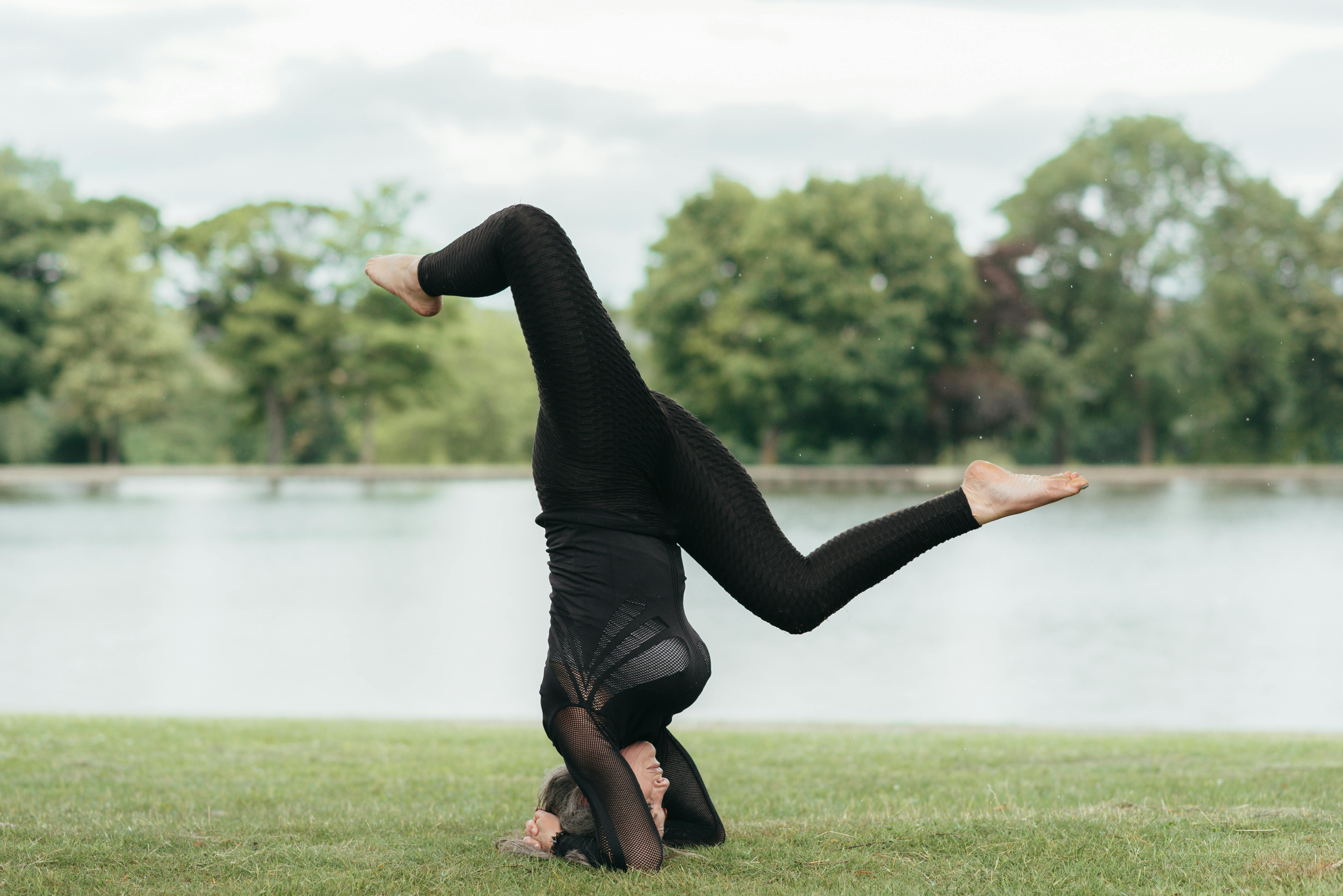 Flexible woman performing Wild Thing pose on grass coast · Free Stock Photo