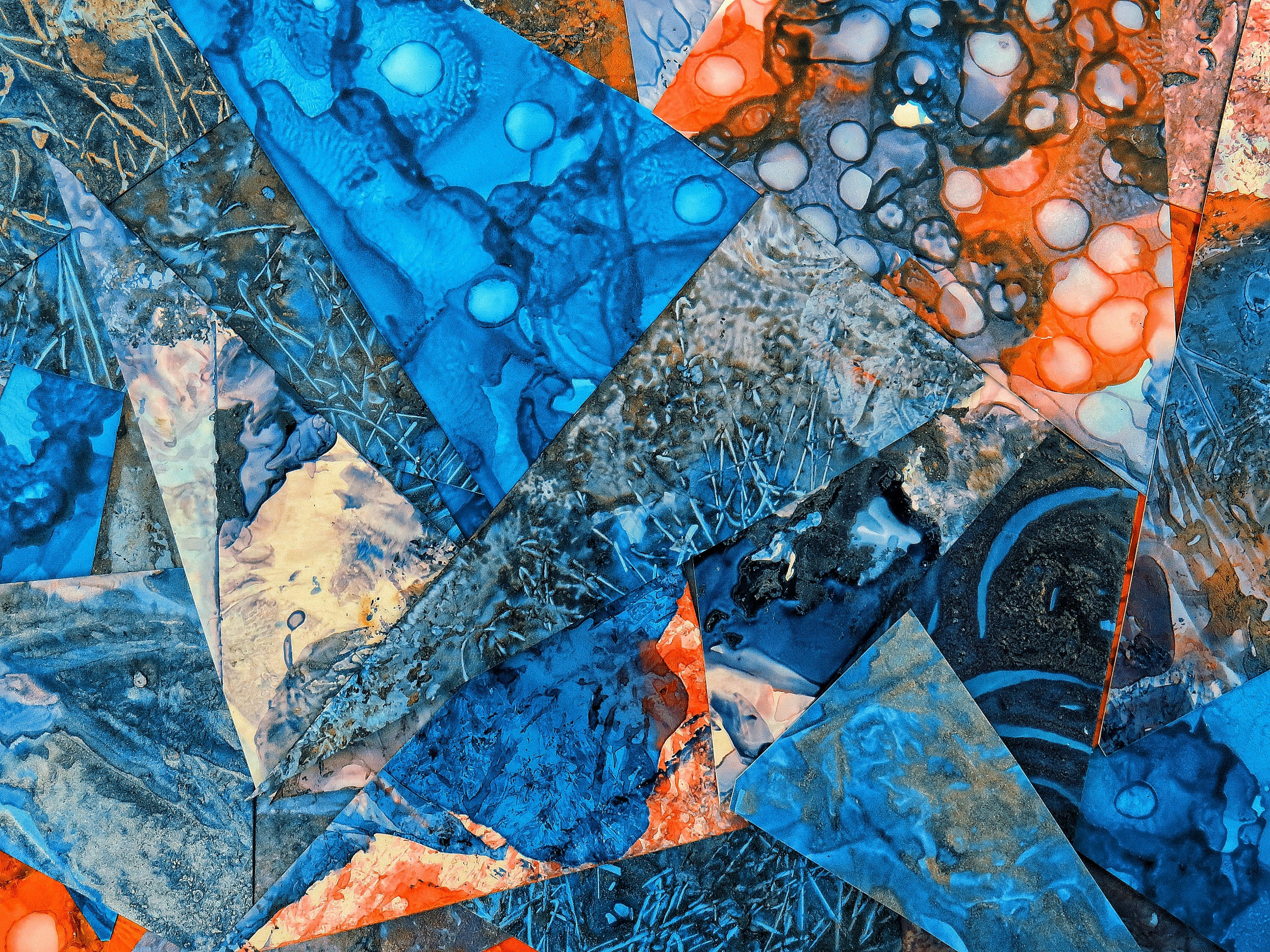 Dynamic abstract art with overlapping vibrant blue and orange geometric shapes creating a textured pattern.