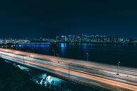 从高空俯瞰，夜间高速公路上城市灯光的轨迹令人惊叹，这反映了城市生活的面貌
