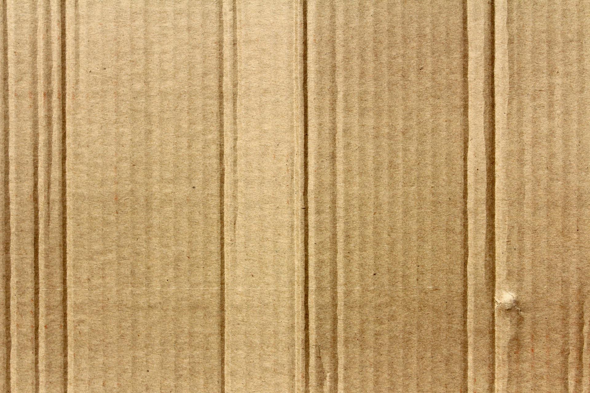 Detailed texture of brown corrugated cardboard, ideal for backgrounds.
