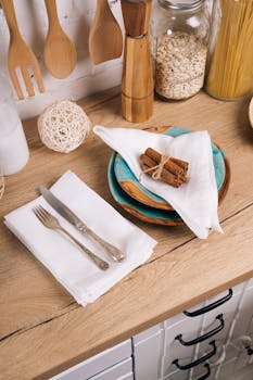 Elegant kitchen countertop setup with wooden utensils, ceramics, and decorative elements.