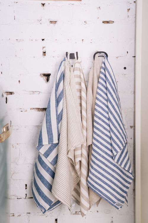 Striped towels hanging on a white brick wall — photo by Tima Miroshnichenko on Pexels