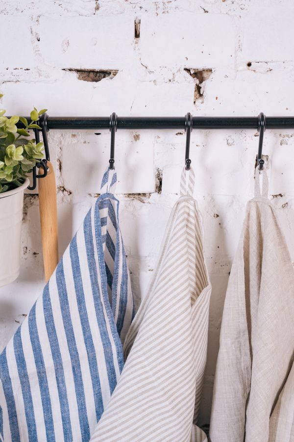 Striped kitchen towels hanging on a wall rail in a small kitchen