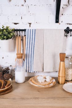 Charming kitchen counter setup with milk bottle, oats, and striped towels. Perfect for rustic home decor.