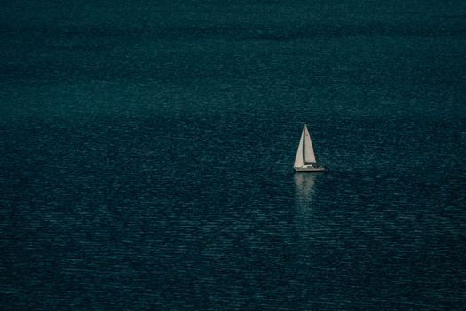 Lonesome sailboat floating on rippling sea