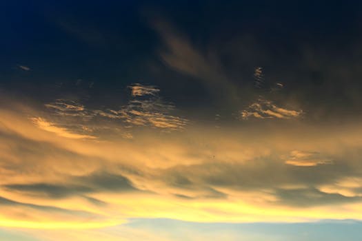 A mesmerizing display of golden clouds at sunset against a deep blue sky, evoking tranquility.