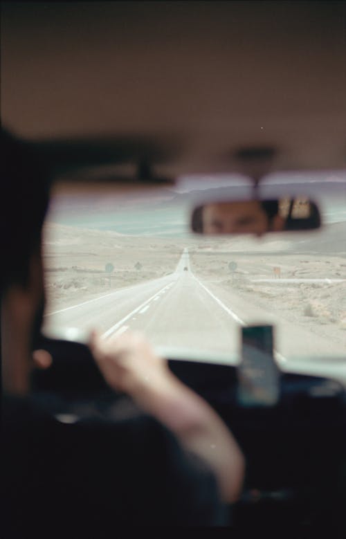 A Man Driving a Car on the Long Road