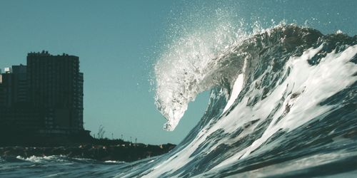 Free Low angle view of a powerful ocean wave crashing near the shore of Mar del Plata under a clear blue sky. Stock Photo