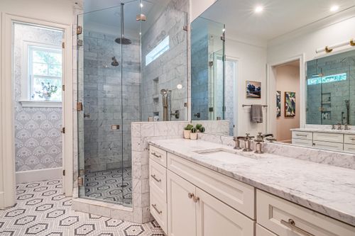 Free Elegant bathroom with marble countertops, glass shower, and stylish Mediterranean decor. Stock Photo