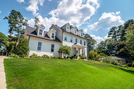 Beautiful suburban home with lush green lawn and clear blue sky.