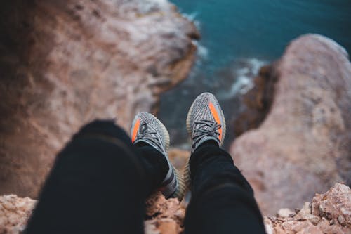 Anonymous traveler admiring sea from rough cliff