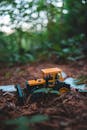 Toy tractor on ground in forest