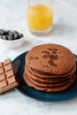 From above of portion of delicious brown hotcakes with chocolate chips near glass of orange juice