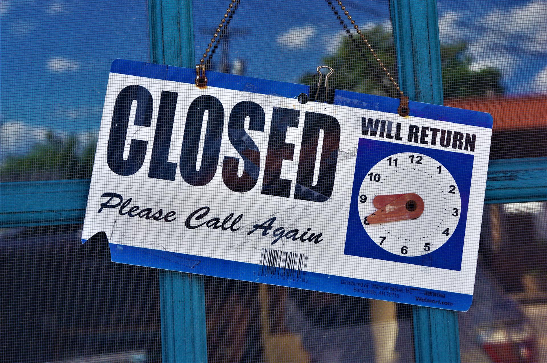 Image of a closed sign on a store door with adjustable return time indicator.