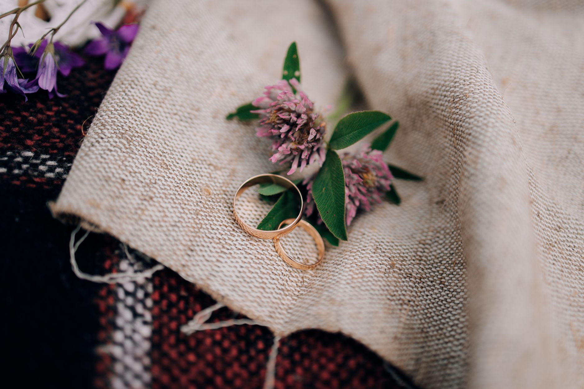 Close-up of wedding rings on linen with flowers, a perfect representation of love and commitment.