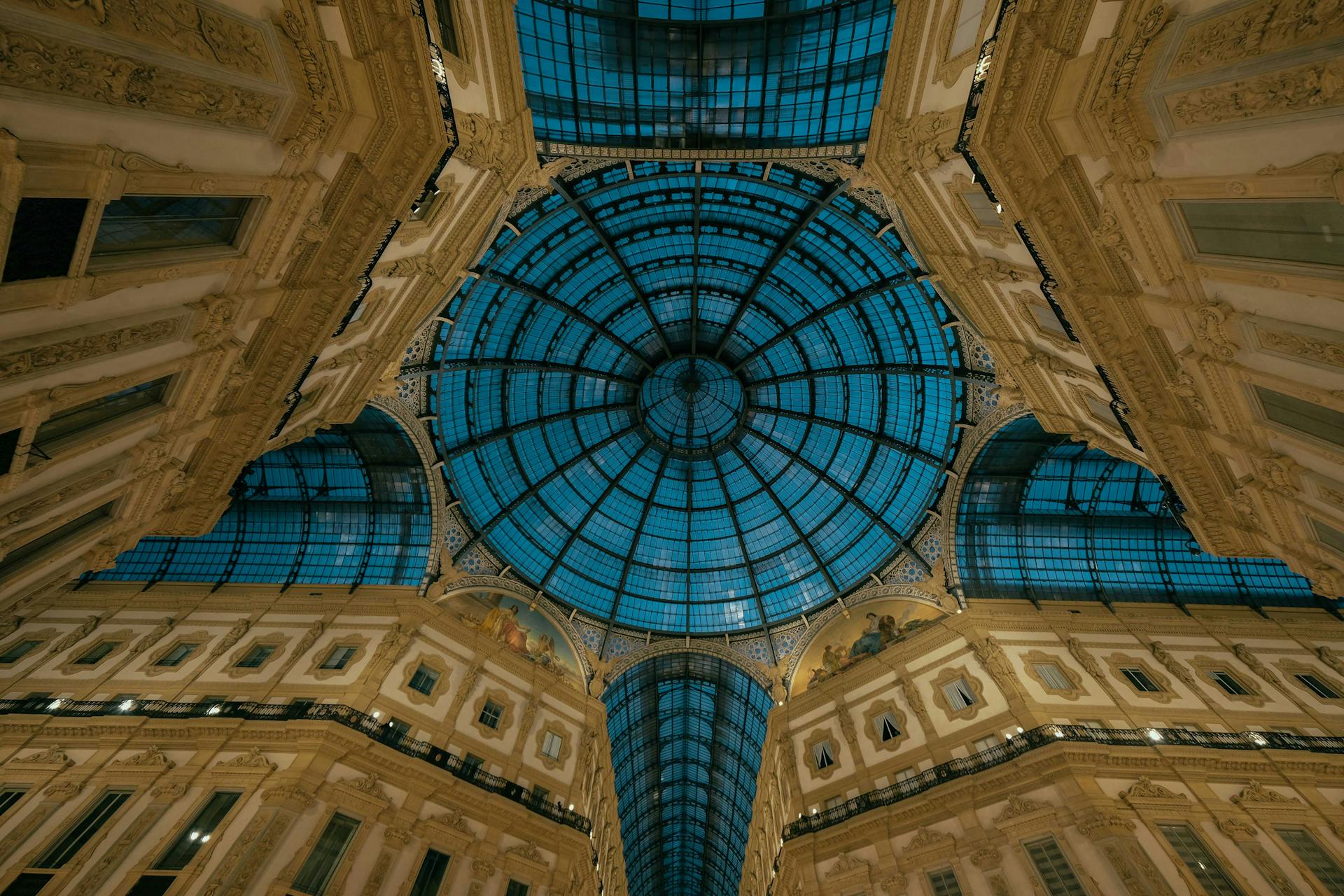 Low angle wonderful ornamental roof of historical Galleria Vittorio Emanuele consisting of barrel vaults and decorated with mosaic and stucco work