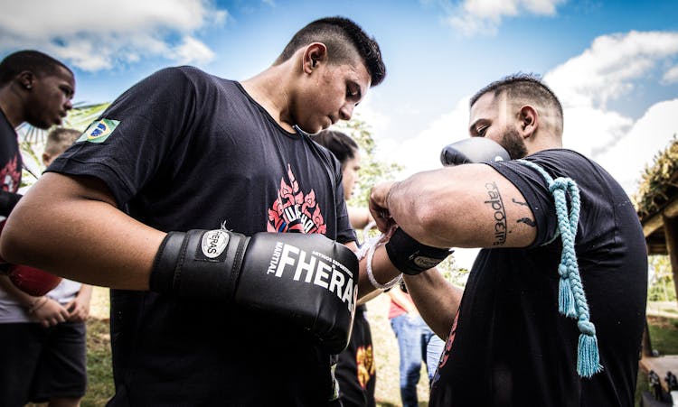 A Trainer Lacing The Boxing Gloves