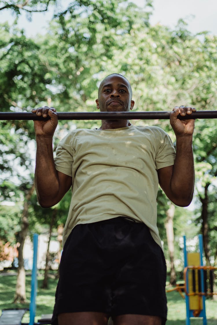 A Man Hanging On A Pull Up Bar