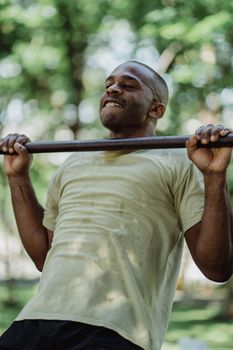 Man doing pull-ups outdoors, showcasing strength and fitness in a natural setting.