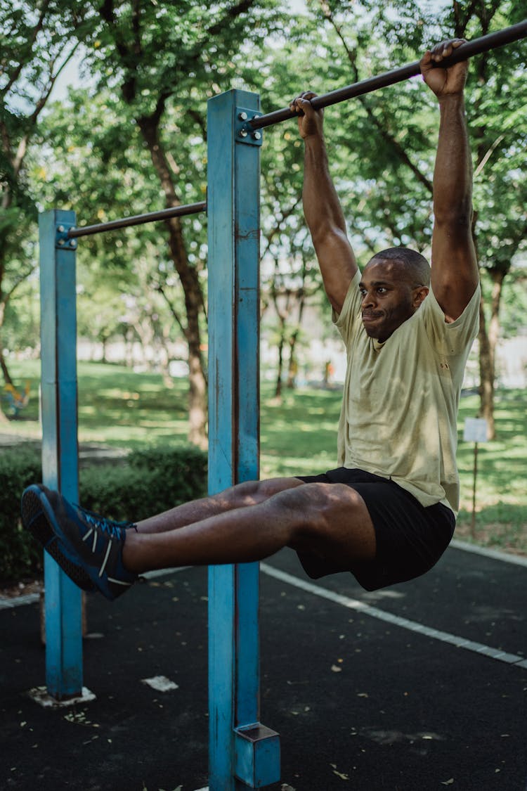 A Man Hanging On A Metal Bar