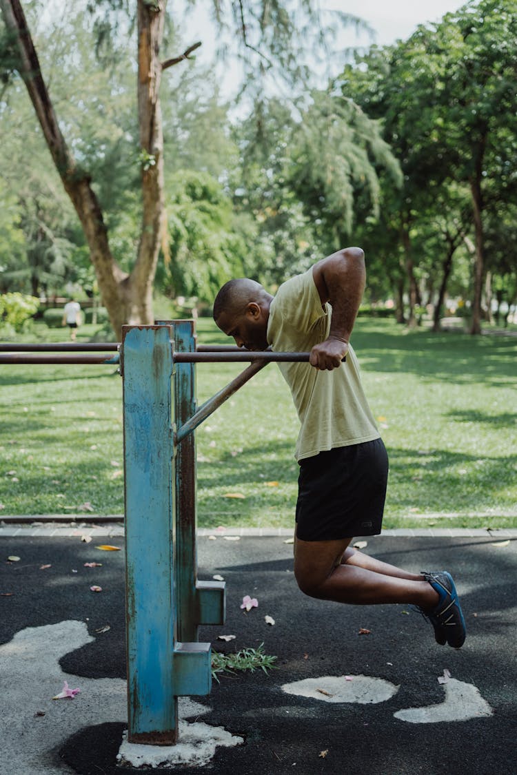 A Man Hanging On A Metal Bar