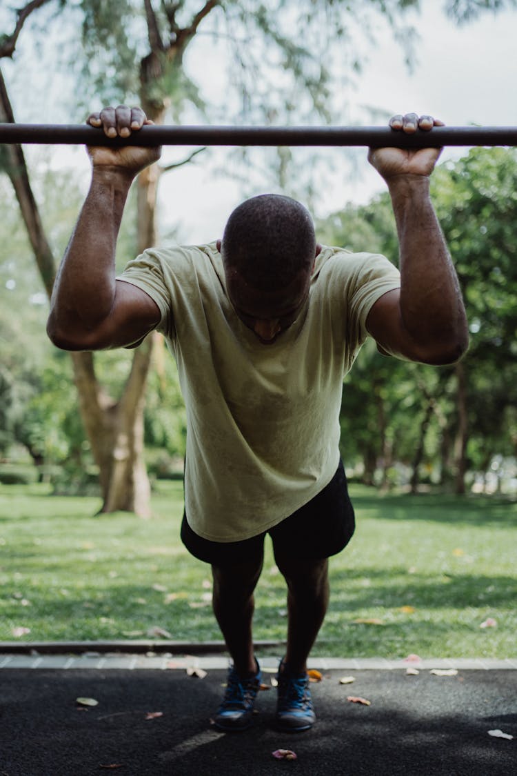 A Man Holding On An Iron Bar