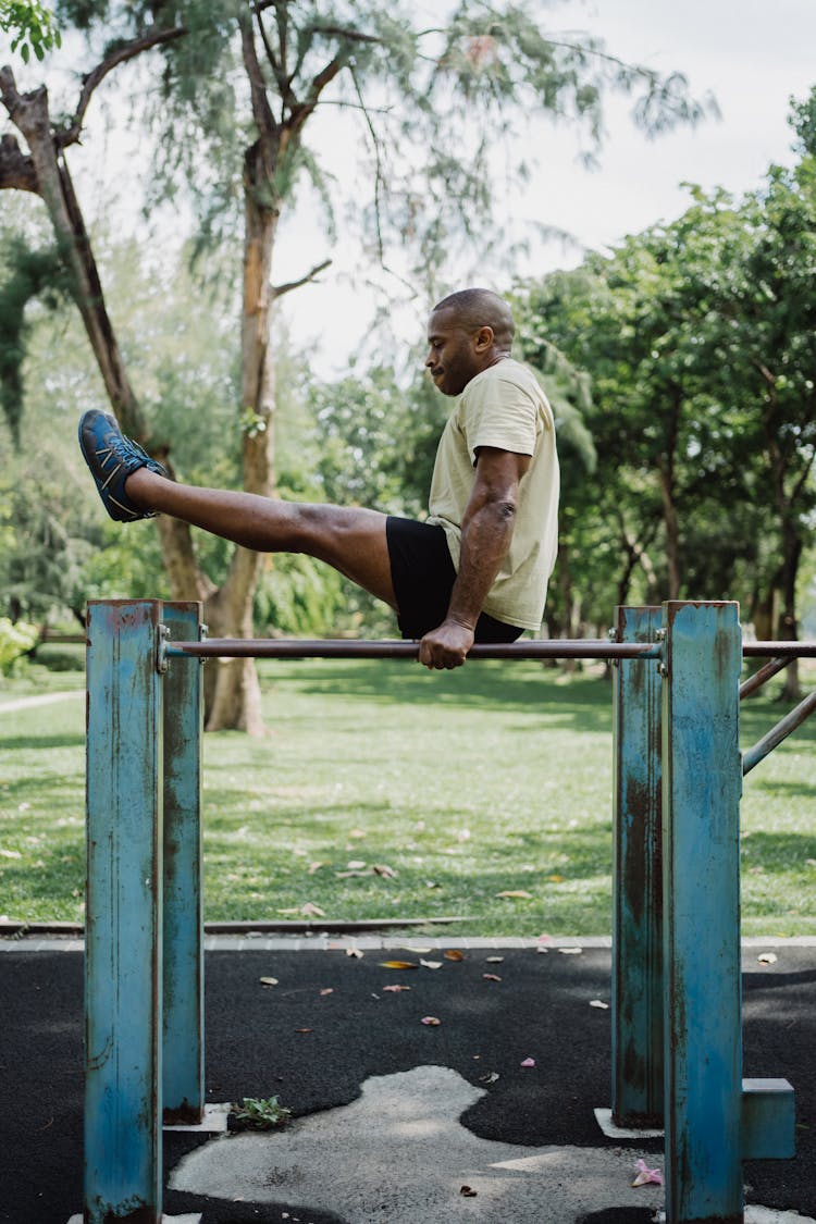 A Man Doing A Leg Raise On A Dip Bar