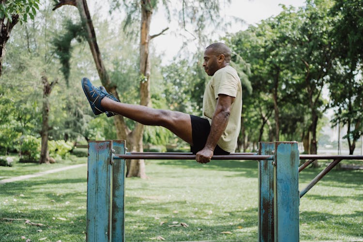 A Man Doing A Leg Raise On A Dip Bar