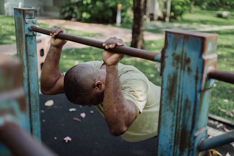 A Man Holding On An Iron Bar