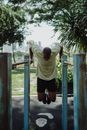 一名男子在公园的双杠上锻炼，背景是城市的天际线
