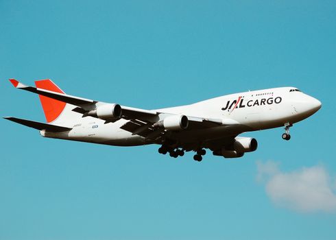 A large cargo airplane in flight against a clear blue sky, showcasing aviation and transportation.