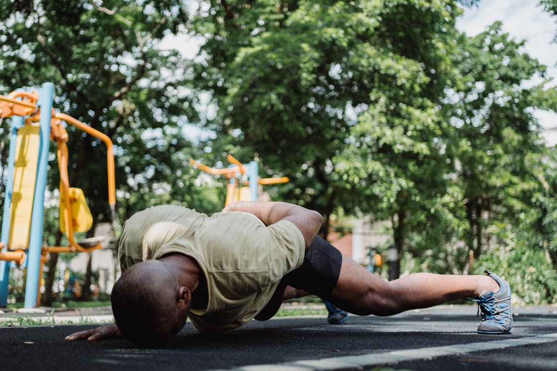 Man in One Arm Push Ups with Forehead Touching the Pavement