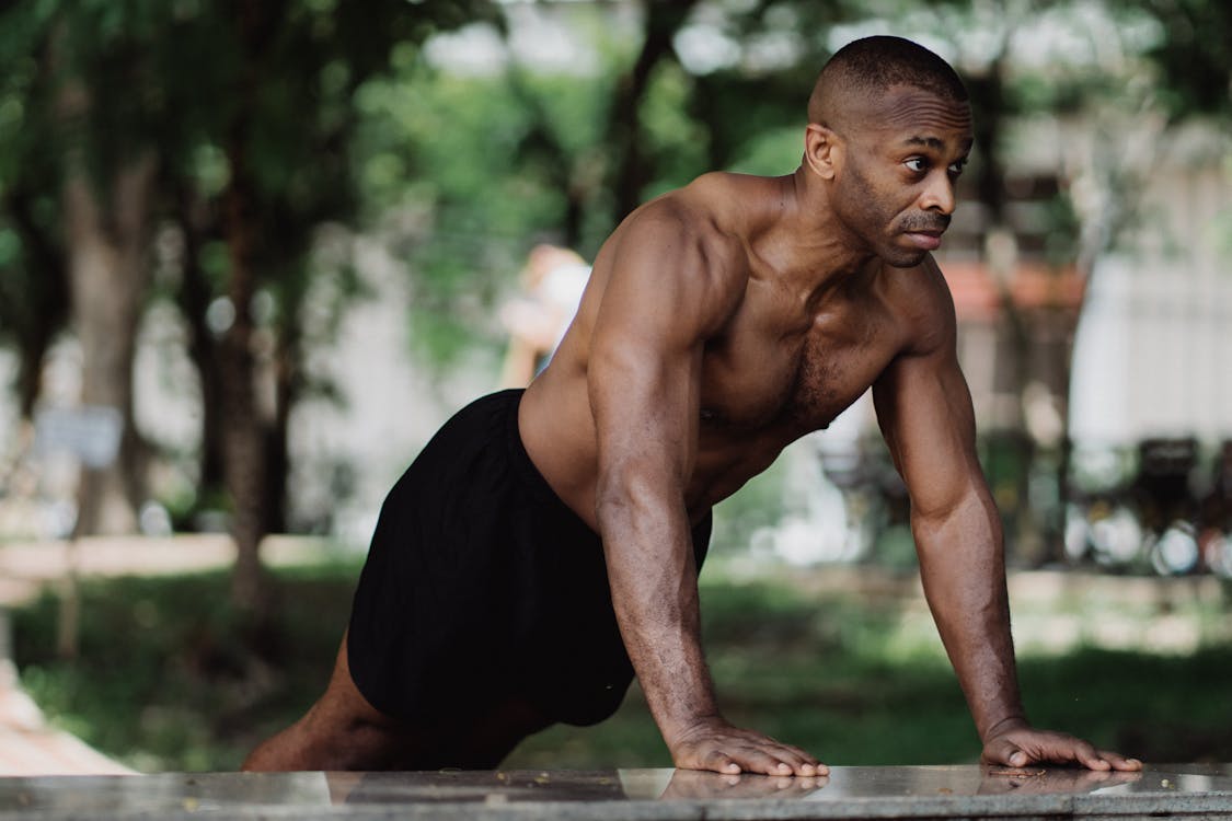 Free Topless Man in Black Shorts Doing Push Up Training Stock Photo
