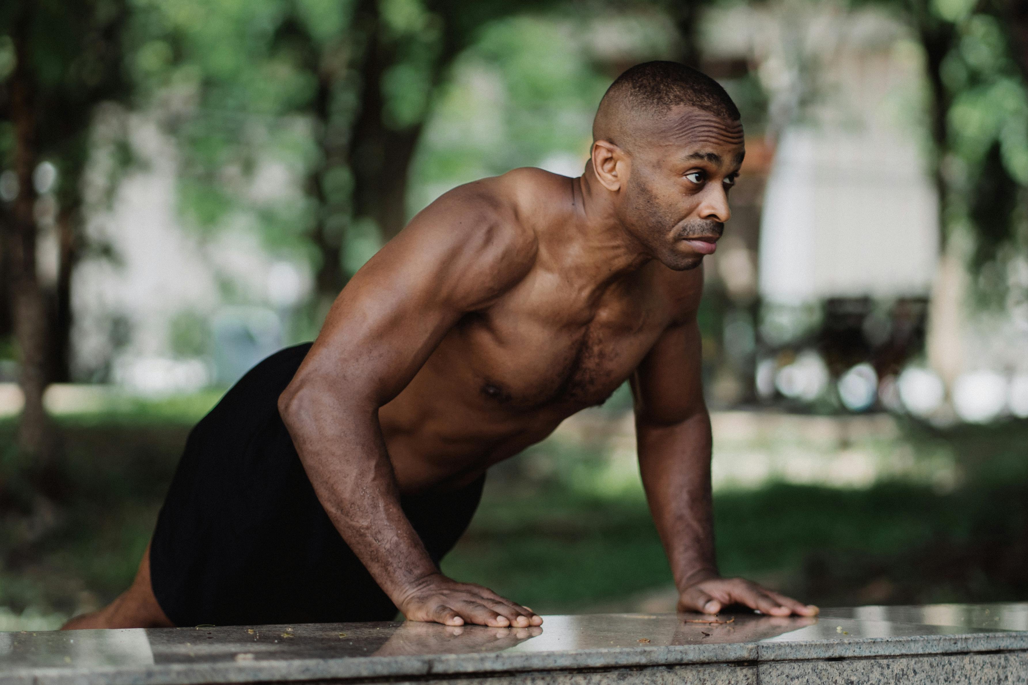 Fit man performing push-up exercise outdoors, focusing on strength and fitness.