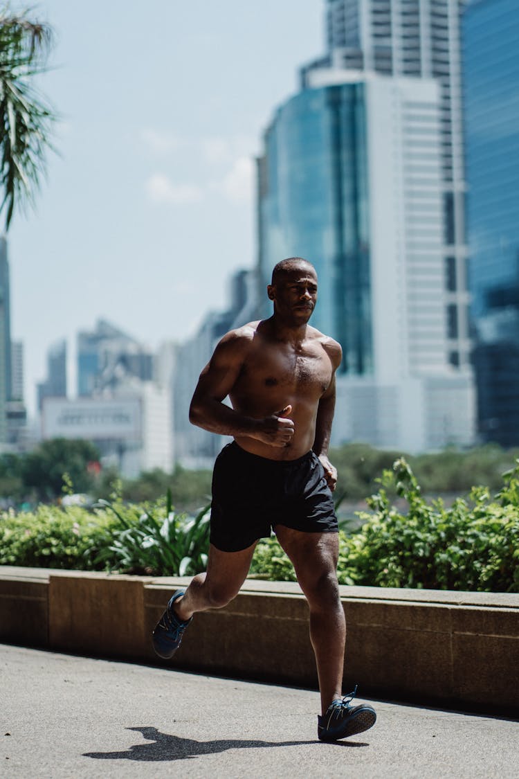 Shirtless Well Built Man Running Along The Sidewalk