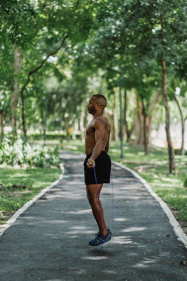 Topless Man On Black Shorts Exercising With Jumping Rope