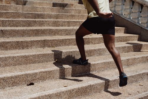 Free Athlete in black shorts running up outdoor concrete stairs during daytime. Stock Photo
