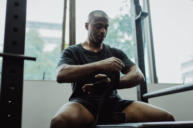 A Masculine Man Putting Black Bandage On His Hand