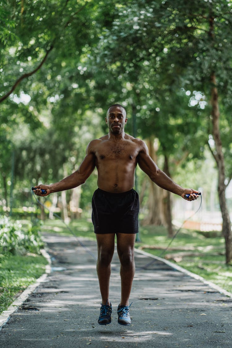 Outdoor Portrait Of Shirtless Man Using Jumping Rope