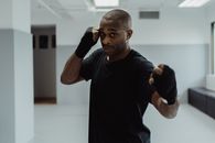 Man in Black Shirt with Black Bandages on His Hand Seriously Looking at the Camera