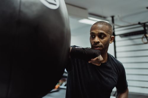 Free A determined boxer practices punches on a heavy bag, showcasing strength and focus during a workout. Stock Photo