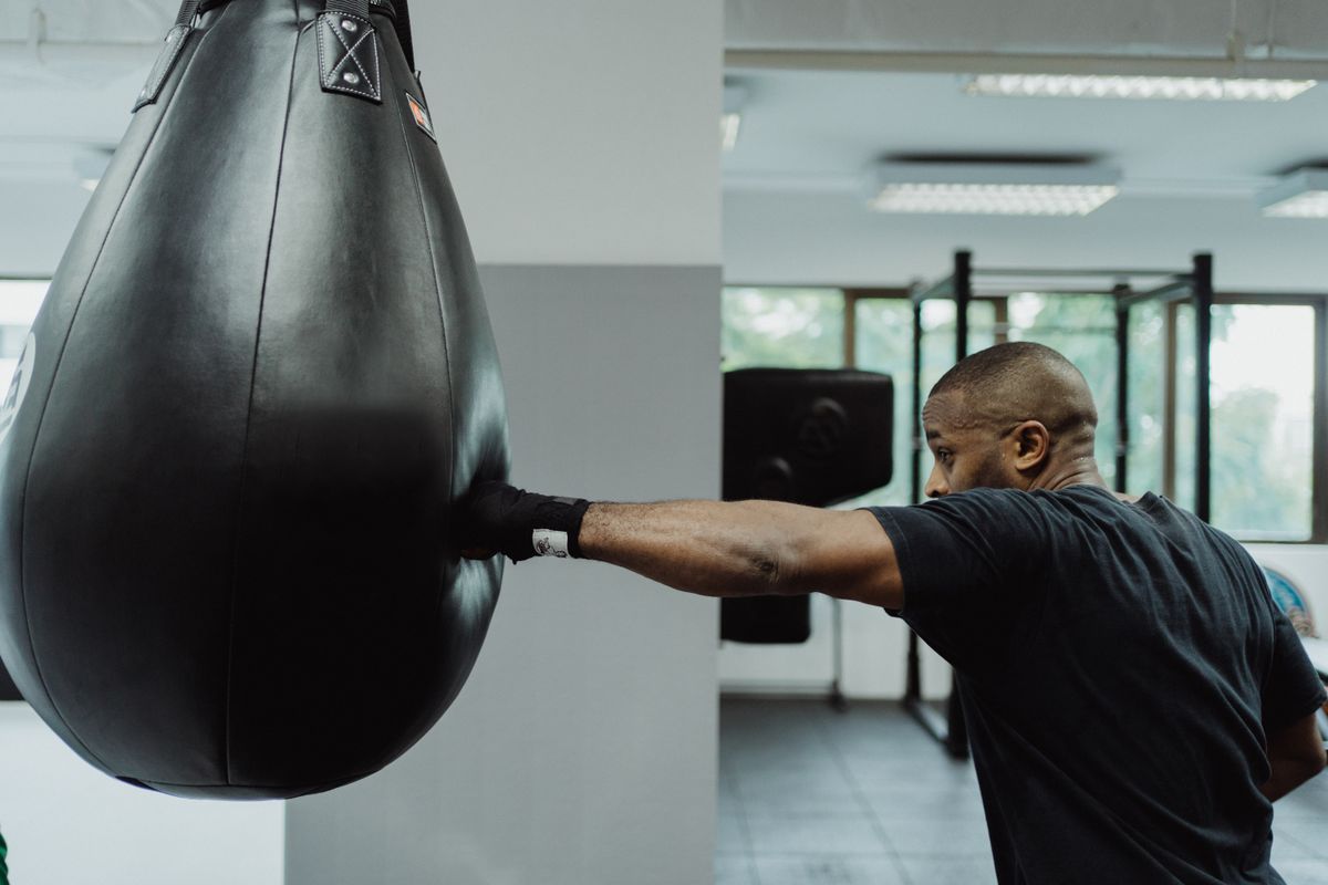 Boxer practicing punches on a heavy bag in a gym
