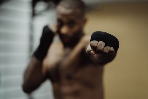 Free A boxer with wrapped hands in focus, ready to strike, highlighting determination. Stock Photo